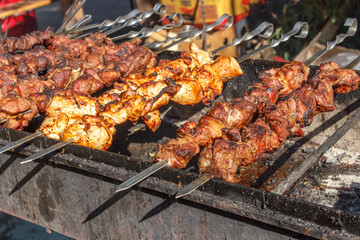 process of cooking meat on skewers on the grill