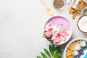 Obraz na płótnie Canvas Pink and blue smoothie in bowl with pitaya, strawberry and raspberry