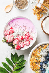 Fototapeta na wymiar Pink and blue smoothie in bowl with pitaya, strawberry and raspberry