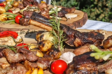 Grilled meat with grilled vegetables and spices on a wooden table.