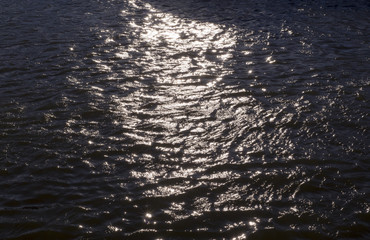 reflections of evening sun on rippled water in the river. background, texture, nature