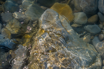 pebble stones on the sea beach, the rolling waves of the sea with foam