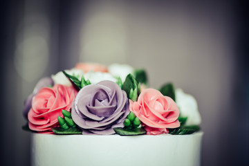 A beautiful elegant flower cake for birthday or wedding party in a vintage style.  Wedding cake, birthday cake. Pink, violet, white, green. yellow. Rose cake