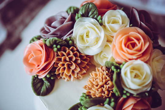 A beautiful elegant flower cake for birthday or wedding party in a vintage style.  Wedding cake, birthday cake. Pink, violet, white, green. yellow. Rose cake