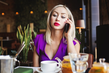 Pretty woman with smartphone in restaurant