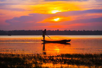Colorful of sunset timing reflection on sea with longboat foreground 