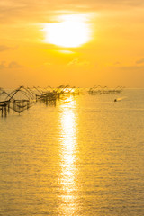 Fototapeta premium golden sky above fishing trap in Pak Pra Talay Noi sea Phatthalung south of Thailand