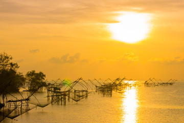 Fototapeta na wymiar golden sky above fishing trap in Pak Pra Talay Noi sea Phatthalung south of Thailand