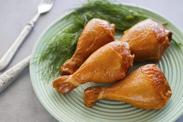 Smoked chicken drumsticks on a green plate.