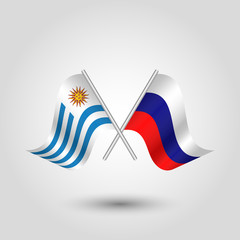 vector two crossed uruguayan and russian flags on silver sticks - symbol of uruguay and russia