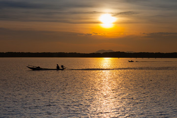 Naklejka na ściany i meble Colorful of sunset timing reflection on sea with longboat foreground 