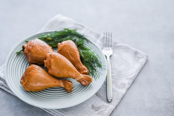 Smoked chicken drumsticks on a green plate.