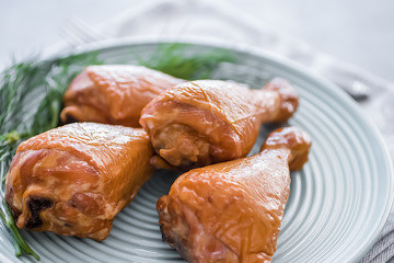 Smoked chicken drumsticks on a green plate.
