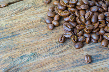 close up of medium or dark roasted coffee bean on the grunge wood surface. copy space for text.