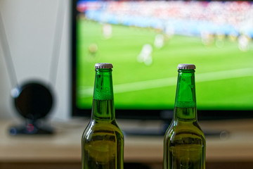 Two bottles of beer during watching football match on tv