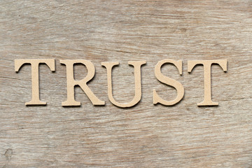 Alphabet letter in word trust on wood background