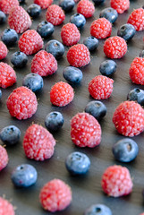 close up on raspberries and blueberries arranged as a pattern