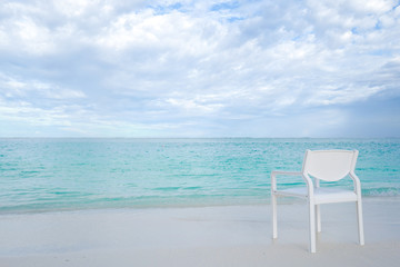 Summer concept , White chair on the beach white sand and turquoise sea color at maldives on the weekend holidays