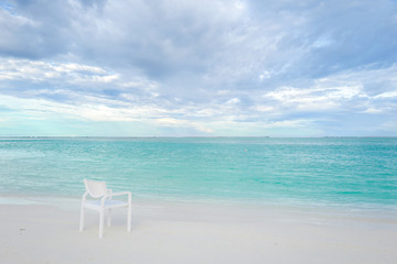 Summer concept , White chair on the beach white sand and turquoise sea color at maldives on the weekend holidays