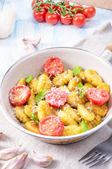 gnocchi baked with green pesto, cherry tomatoes and parmesan