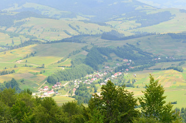 Obraz premium Outstanding landscape from a height. Green forest and village in the mountains. Ukrainian Carpathians