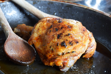 a piece of fried chicken in a fat pan