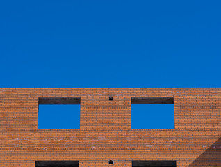 Closeup on two windows hole construction with concrete lintel. Unfinished house.