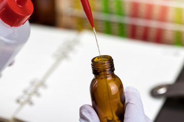 Researcher is dropping the reagent into test tube.Scientist working at the laboratory.