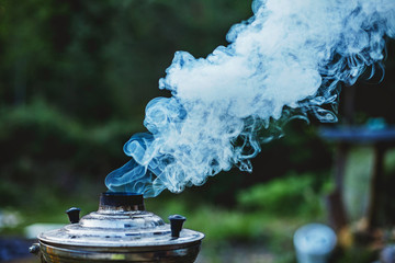Atmospheric picture of thick  clouds of blueish smoke rising from a chimney of old traditional...