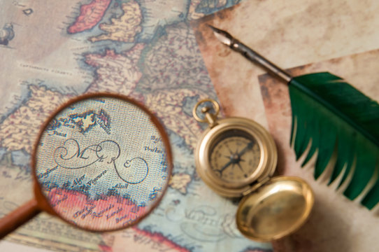 Planning a trip: closeup view of a magnifying glass on an old map with vintage items