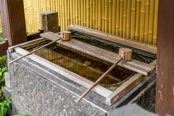 Stillness at the water basin at the entrance of a shrine in Japan for the riual Temizuya...