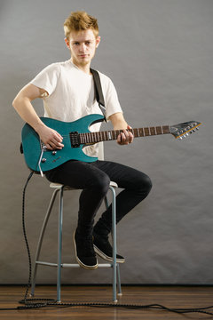 Young man playing electric guitar