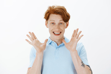 Listen, I have incredible news. Positive happy redhead guy with freckles, raising palms near face...