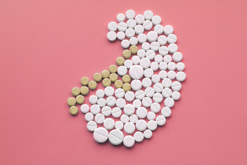 Kidney made of pills on pink background. World Kidney Day concept