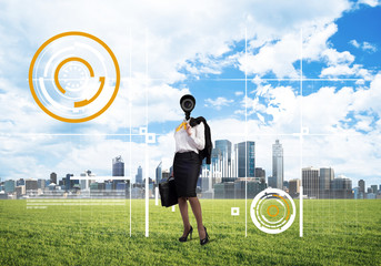 Camera headed woman standing on green grass against modern cityscape