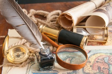 Planning a trip: quill pen, old papers and maps with vintage items
