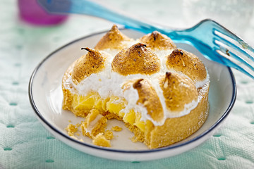 Lemon meringue mini tart with plastic fork 