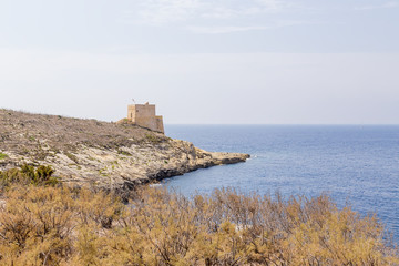 Fototapeta na wymiar The island of Gozo, Malta. The Xlendi Tower (1650) at the entrance to the eponymous bay