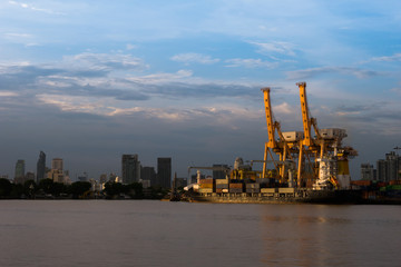 Obraz premium A shipping crane of maritime transportation beside river