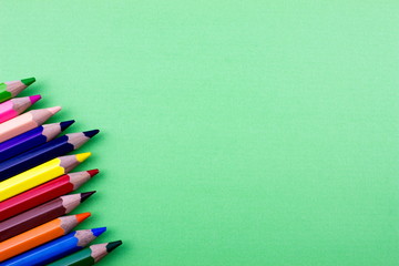 Pencils set on green tone color paper. Empty space for text and design. Minimalism concept