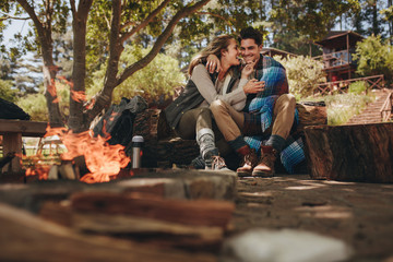 Obraz na płótnie Canvas Loving couple relaxing near campfire