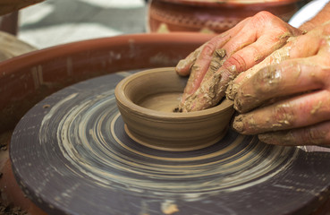 hand maid, molding from clay, making dishes.