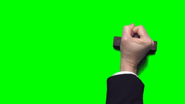 Businessman's hand stamping with a rubber stamp on a chroma key green background