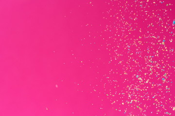 Crumbs of a multicolored chalk fly on a pink background. Joy, Carnival. Game for children