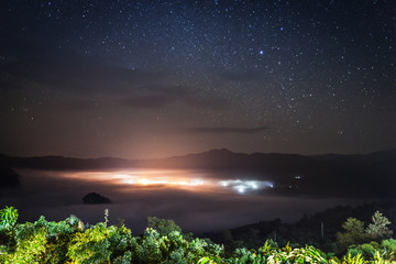 Milky way with foggy and cloudy on mountain located at north of thailand