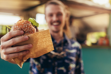 Man offering a food truck burger