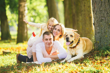 Happy family with their dog in the park on a sunny day