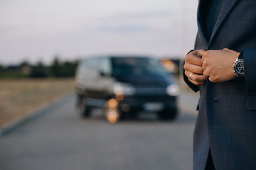 Man in suit stay in front of luxury car minivan - obrazy, fototapety, plakaty