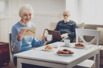 My youth. Positive joyful woman looking at the photo while remembering her youth