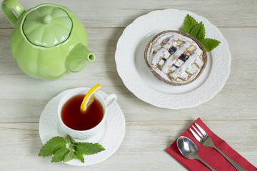 Refreshment working day concept: Cup of herbal linden tea, apple pie on white background. Flat lay